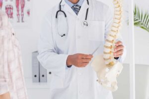 A chiropractor gently adjusting an adult patient's back in a calm clinic setting.